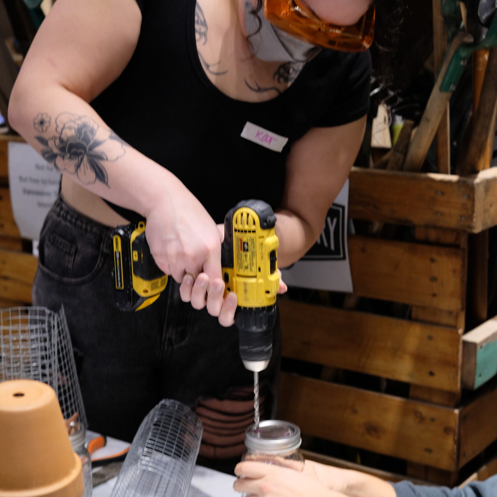 Workshop participant drilling into the lid of a jar